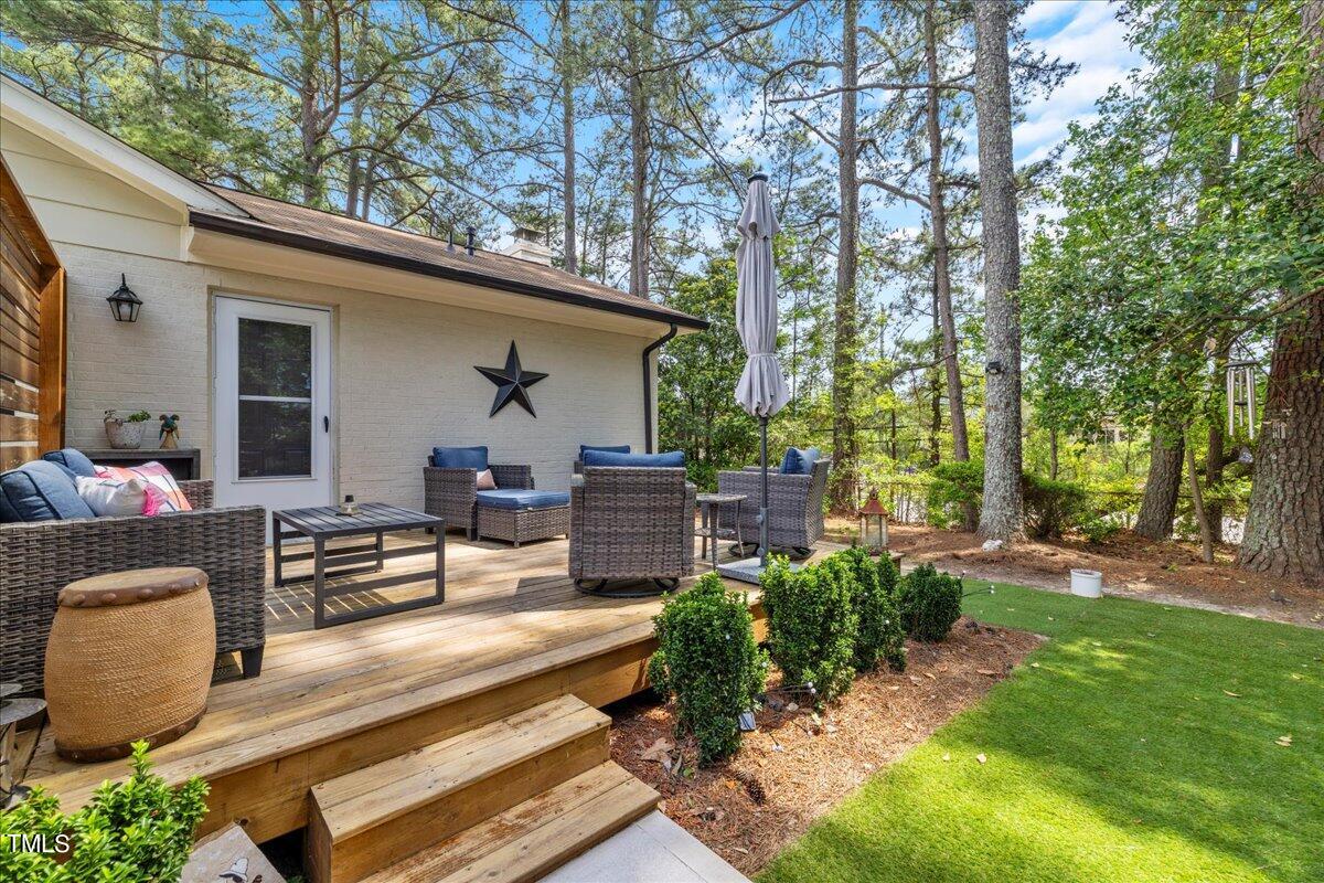 5700 Tully Court Raleigh, NC 27609 - Photo 26 of 26 a view of a patio with couches table and chairs and potted plants with large tree
