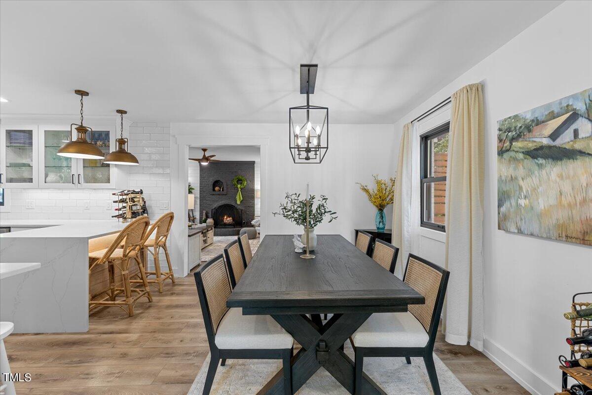 5700 Tully Court Raleigh, NC 27609 - Photo 8 of 26 a view of a dining room with furniture wooden floor and a chandelier