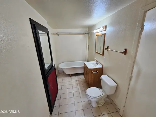 a white toilet sitting next to a bathroom sink and a mirror