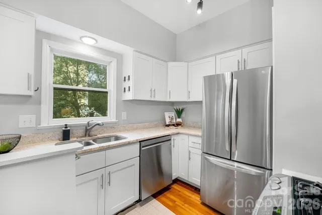a kitchen with appliances a sink and a window