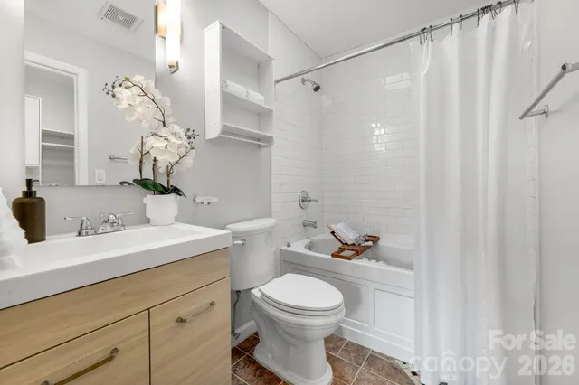 a bathroom with a sink a toilet and shower curtain