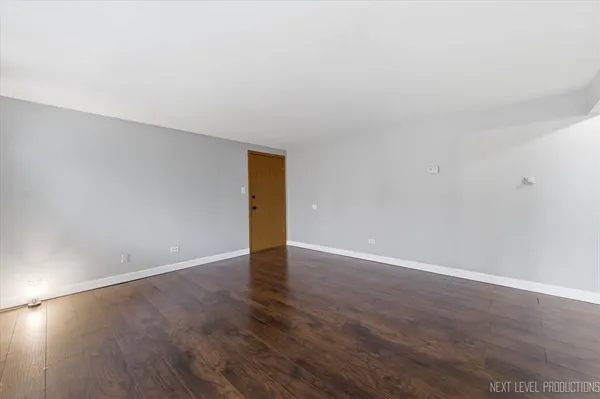 a view of an empty room and wooden floor