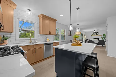 a living room with furniture a fireplace and a large window