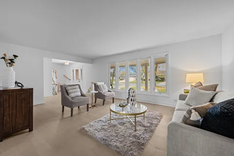 a view of a dining room with furniture a chandelier and a window