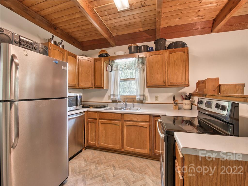86 Confederate Road Clyde, NC 28721 - Photo 12 of 26 a kitchen with stainless steel appliances granite countertop a refrigerator a sink and a stove