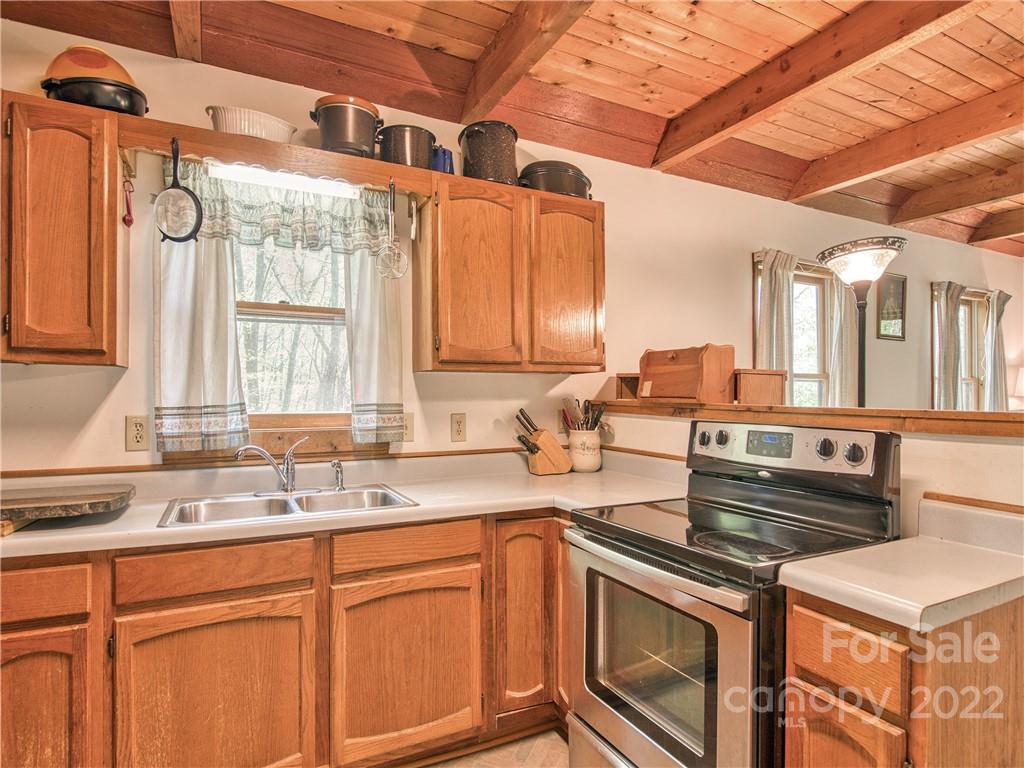86 Confederate Road Clyde, NC 28721 - Photo 13 of 26 a kitchen with stainless steel appliances granite countertop a sink stove and cabinets