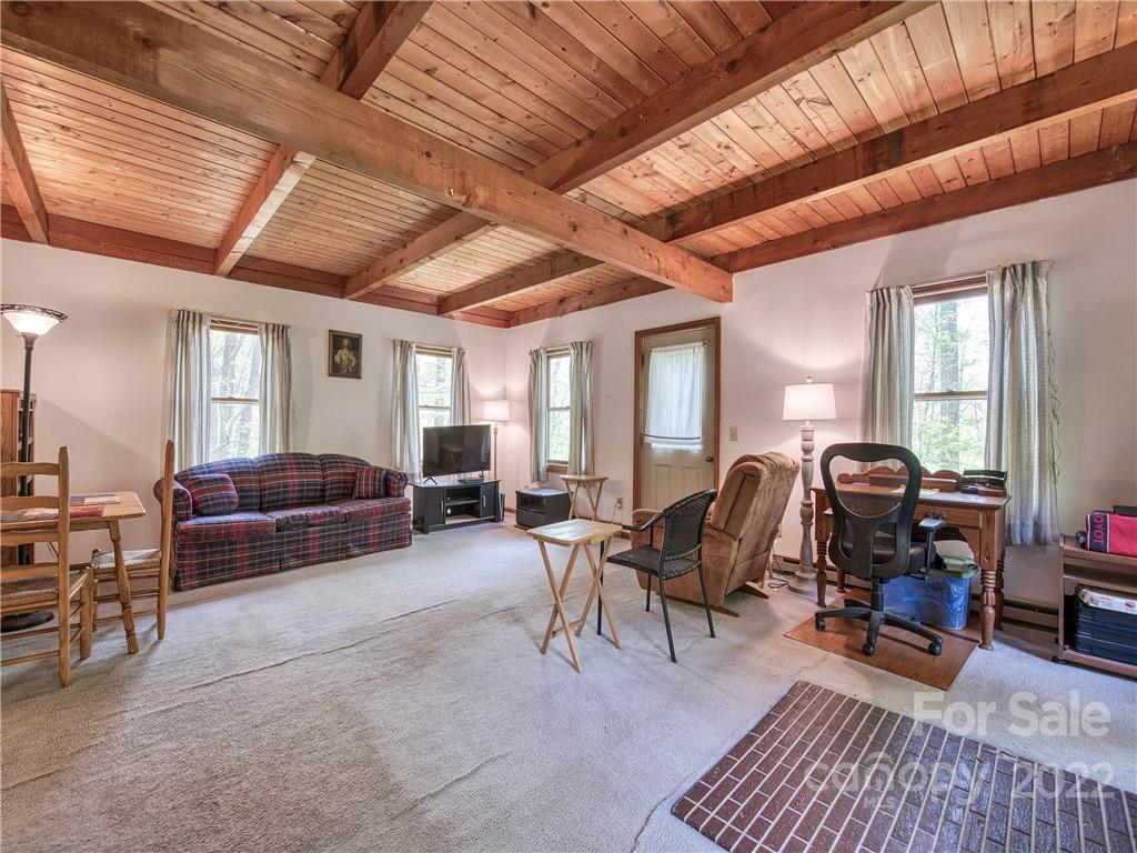 86 Confederate Road Clyde, NC 28721 - Photo 7 of 26 a living room with furniture a flat screen tv and gym equipment