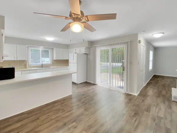a view of a kitchen with wooden floor and a window