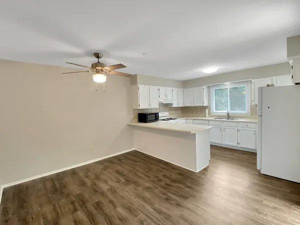 a kitchen with a refrigerator and white cabinets