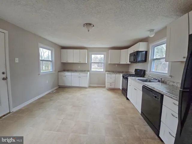 a large kitchen with a stove a sink dishwasher and a refrigerator