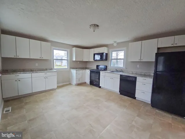 a kitchen with stainless steel appliances granite countertop a refrigerator sink and cabinets