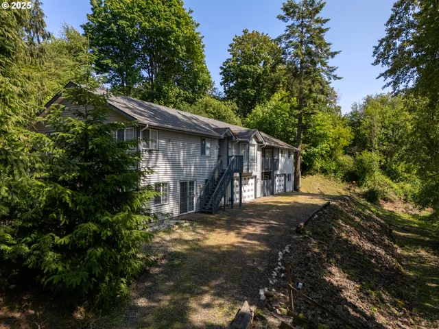 a view of a house with a large tree and a yard