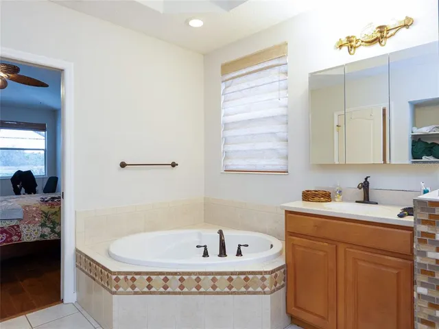 a bathroom with a tub a sink and mirror