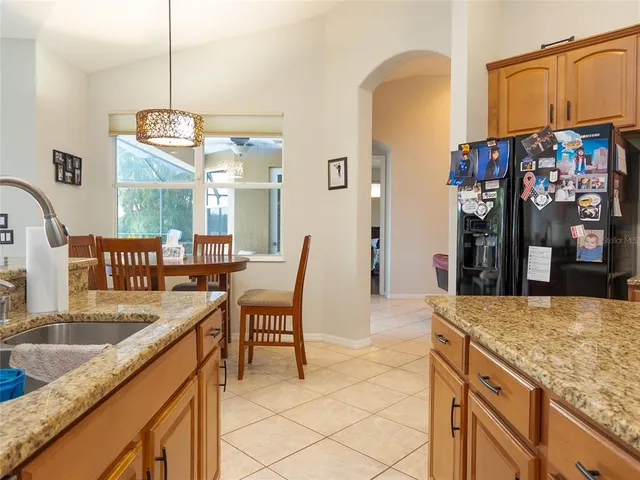 a kitchen with stainless steel appliances granite countertop a sink and a refrigerator