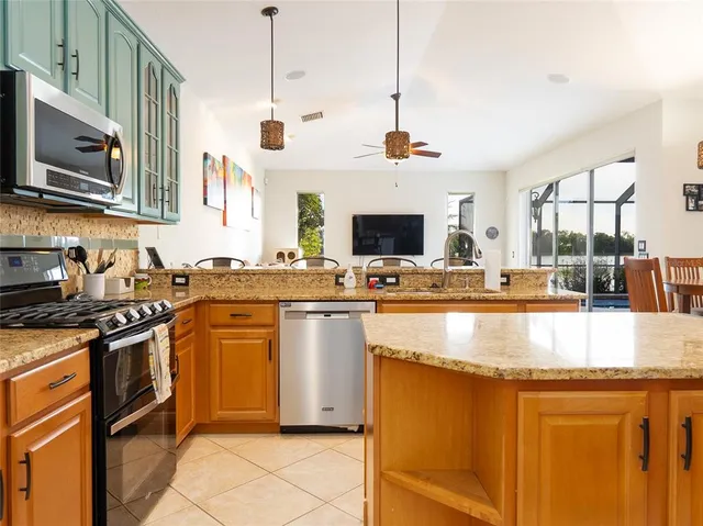 a kitchen with stainless steel appliances granite countertop a sink a stove and a microwave