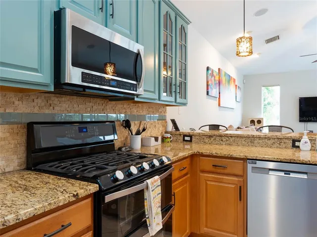 a kitchen with stainless steel appliances granite countertop a stove and a microwave
