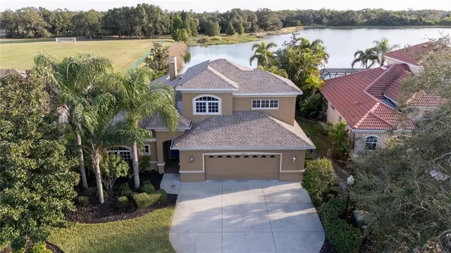 a front view of a house with a yard and lake view