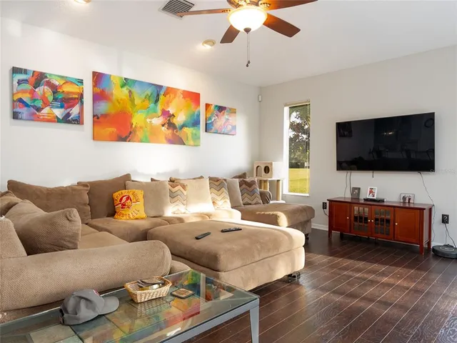 a living room with furniture and a wooden floor