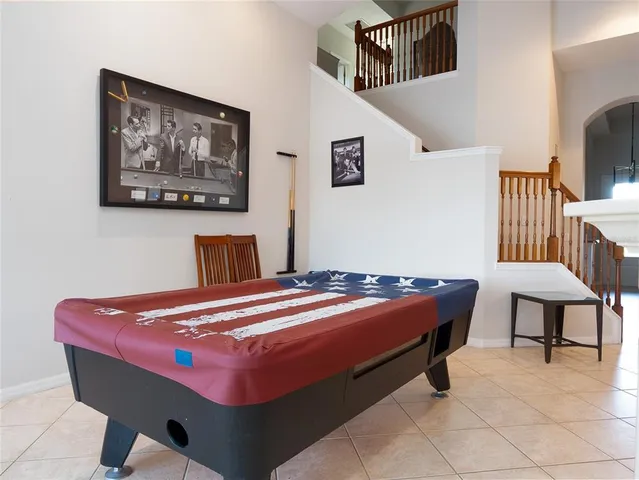 a room with pool table and paintings on the wall