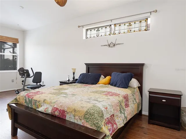 a bedroom with bed and wooden floor