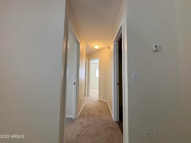a view of a hallway with wooden shelves