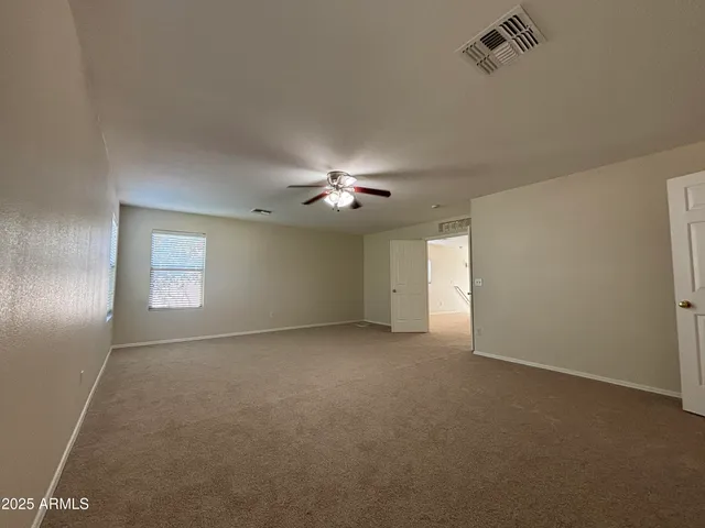 an empty room with a ceiling fan and a window