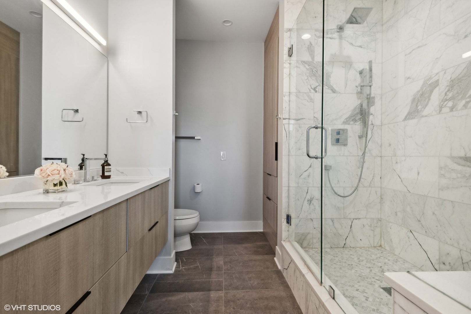 1301 West Madison Street, Unit 501 Chicago, IL 60607 - Photo 16 of 30 a bathroom with a double vanity sink toilet and shower