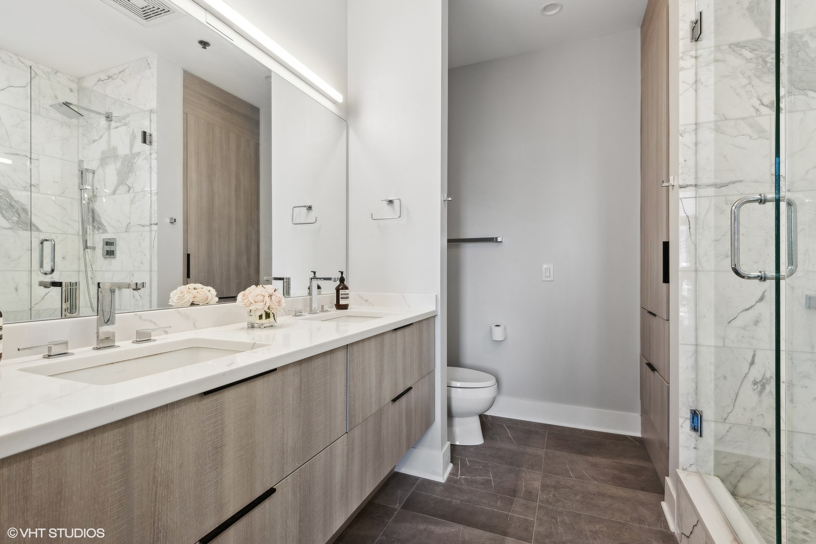 1301 West Madison Street, Unit 501 Chicago, IL 60607 - Photo 17 of 30 a bathroom with a double vanity sink toilet and shower