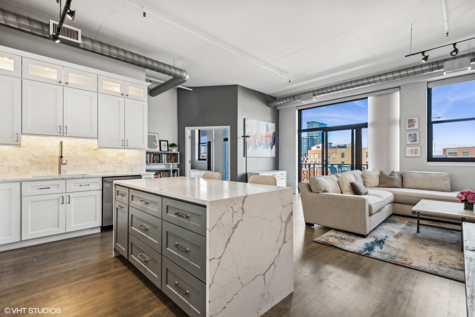 1301 West Madison Street, Unit 501 Chicago, IL 60607 - Photo 2 of 30 a kitchen with kitchen island granite countertop a sink cabinets and wooden floor