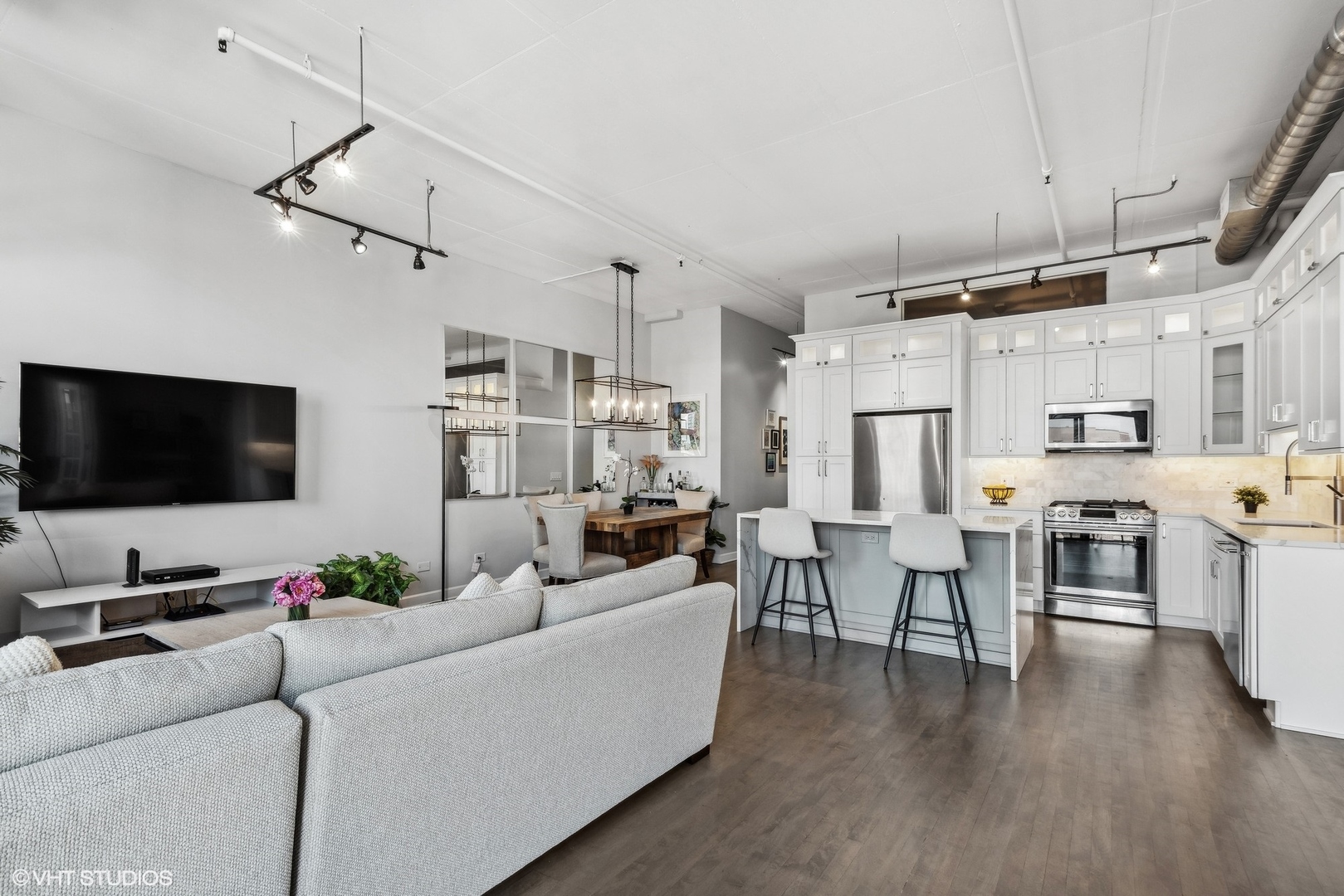 1301 West Madison Street, Unit 501 Chicago, IL 60607 - Photo 7 of 30 a living room with furniture kitchen view and a flat screen tv