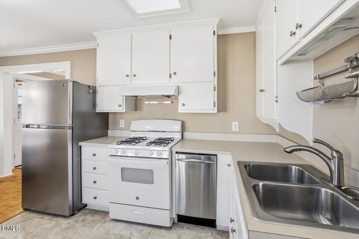 2609 Davis Street Raleigh, NC 27608 - Photo 21 of 31 a kitchen with white cabinets and white stainless steel appliances