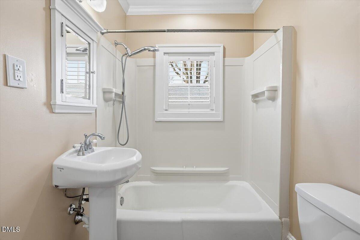 2609 Davis Street Raleigh, NC 27608 - Photo 30 of 31 a bathroom with a sink a mirror bathtub and toilet