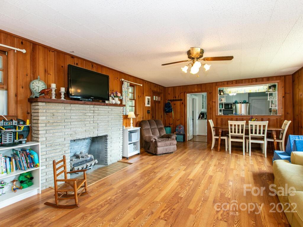 760 Kims Cove Road Canton, NC 28716 - Photo 8 of 37 a living room with furniture a flat screen tv and a fireplace