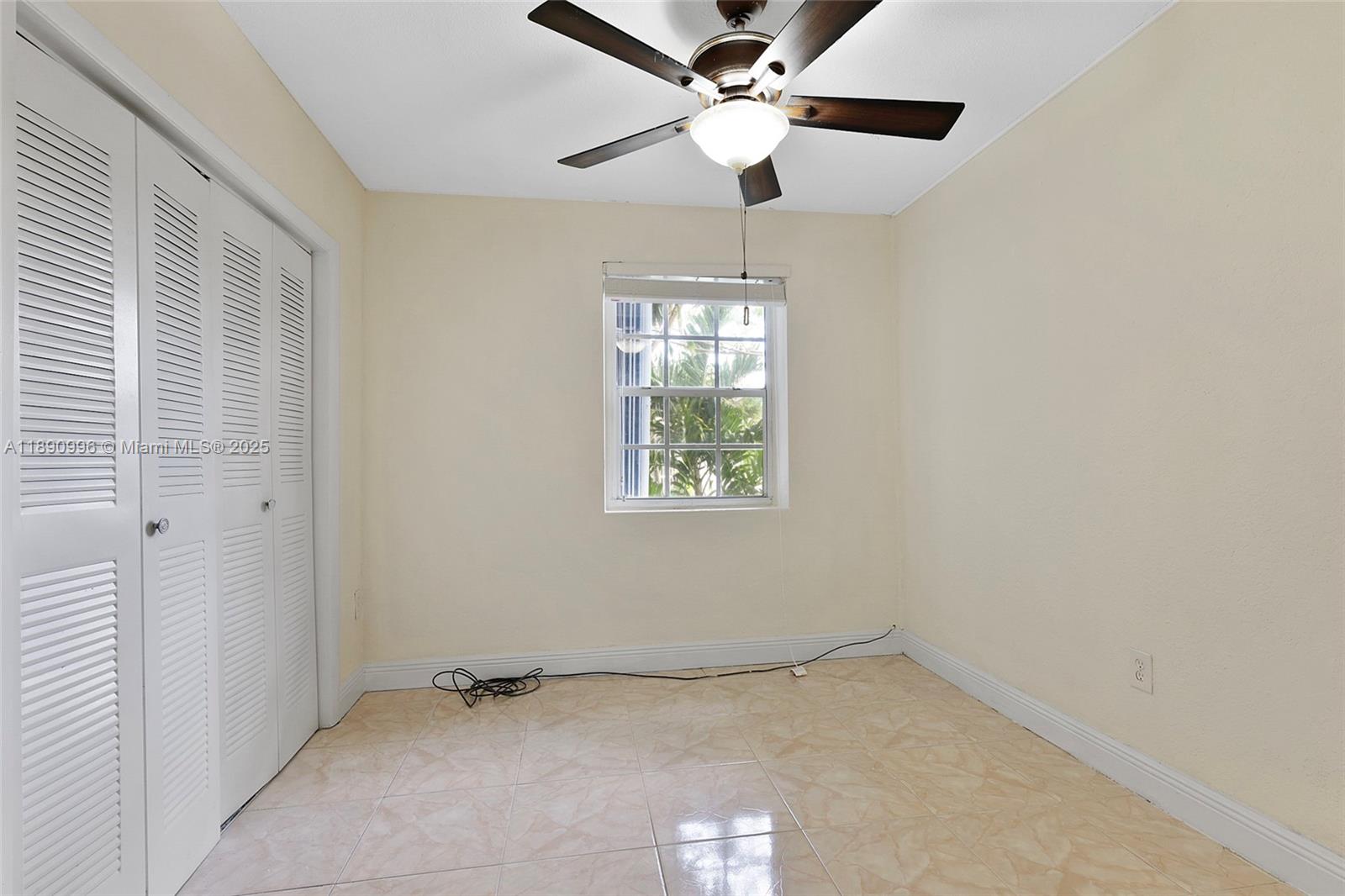 450 Northwest 40th Court Miami, FL 33126 - Photo 12 of 18 an empty room with a window and a fan