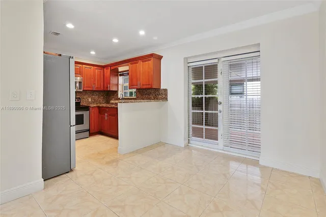 a view of kitchen with kitchen island a sink a counter top space cabinets and stainless steel appliances