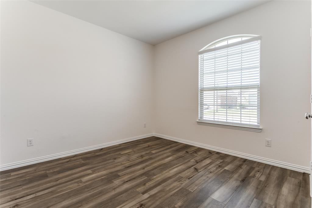 1207 Mesquite Lane Princeton, TX 75407 - Photo 11 of 25 an empty room with wooden floor and windows