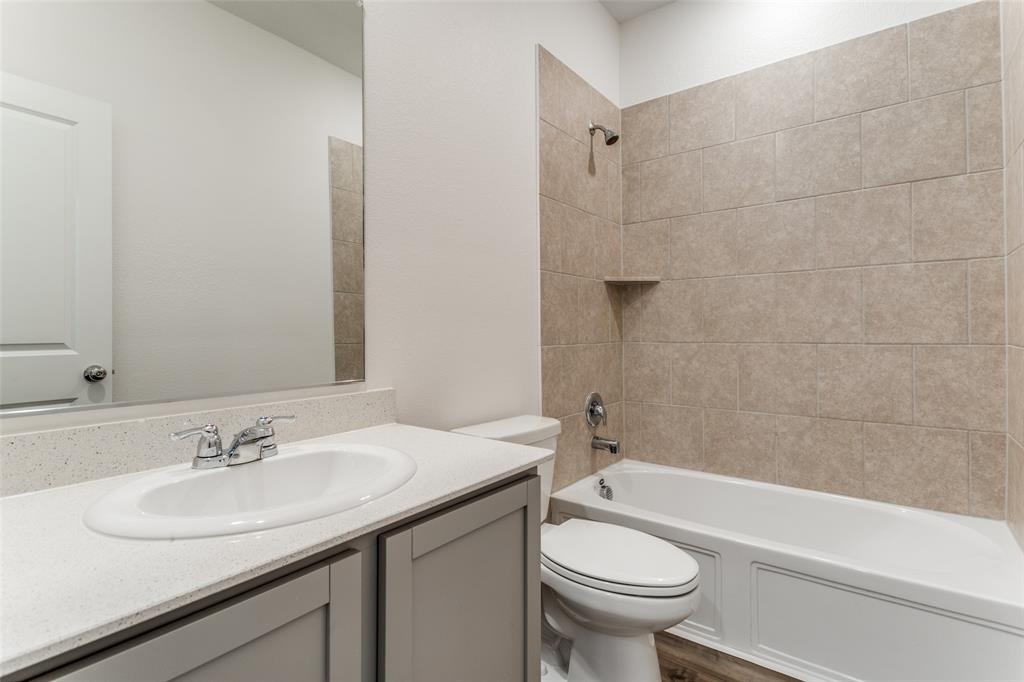 1207 Mesquite Lane Princeton, TX 75407 - Photo 13 of 25 a bathroom with a bathtub shower sink mirror vanity and toilet