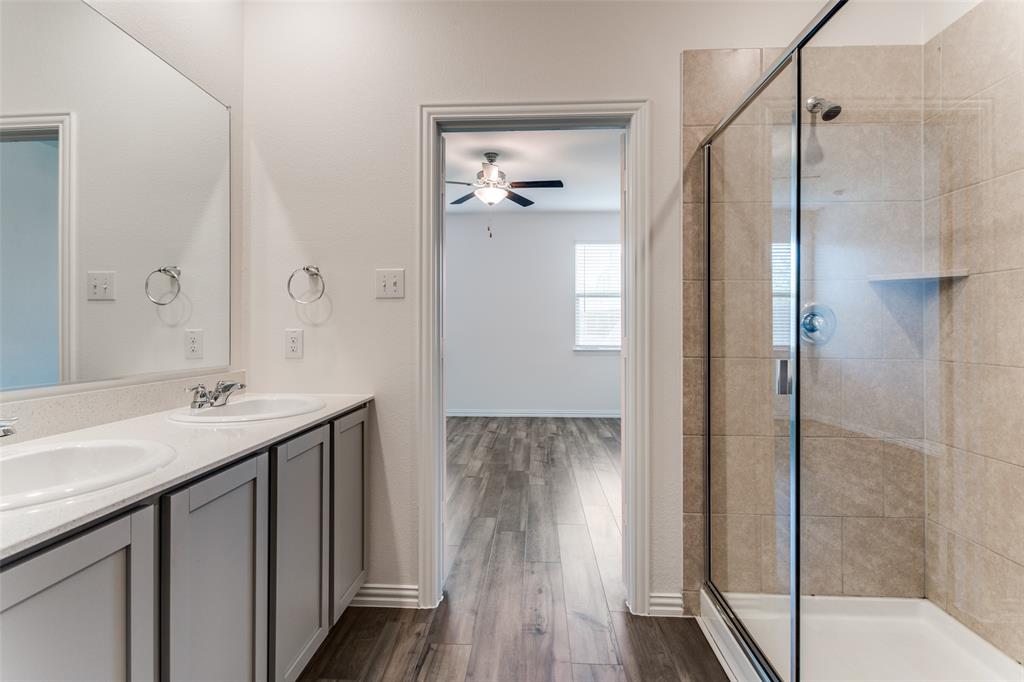 1207 Mesquite Lane Princeton, TX 75407 - Photo 22 of 25 a bathroom with a shower sink and mirror