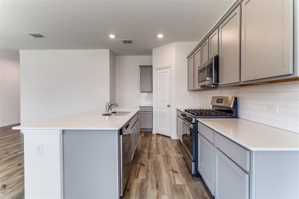 1207 Mesquite Lane Princeton, TX 75407 - Photo 7 of 25 a kitchen with stainless steel appliances granite countertop a sink stove and refrigerator