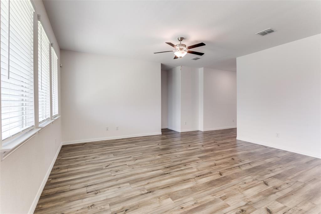 1207 Mesquite Lane Princeton, TX 75407 - Photo 10 of 25 a view of an empty room with wooden floor and a window
