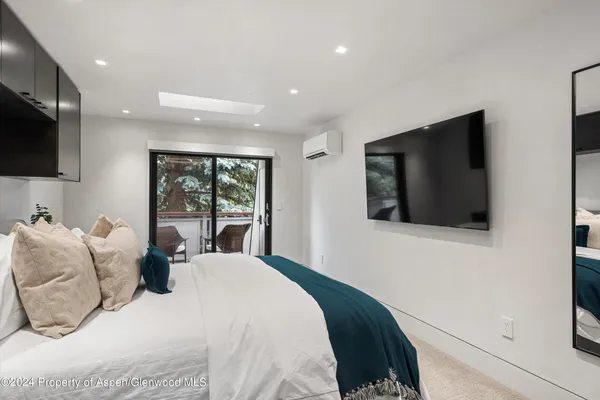 a bedroom with a large bed and a flat screen tv