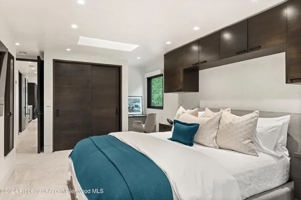 a bedroom with a large bed and a large mirror