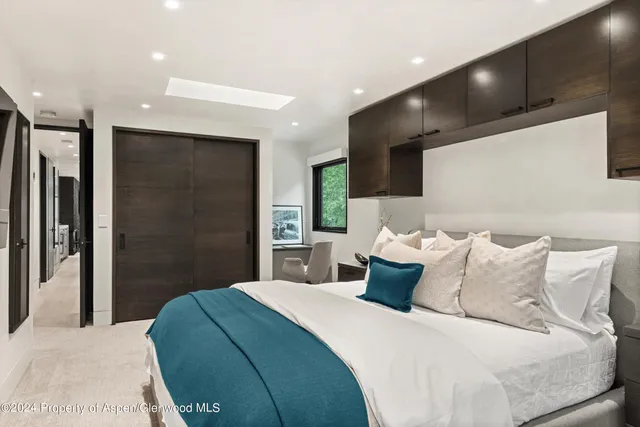 a bedroom with a large bed and a large mirror