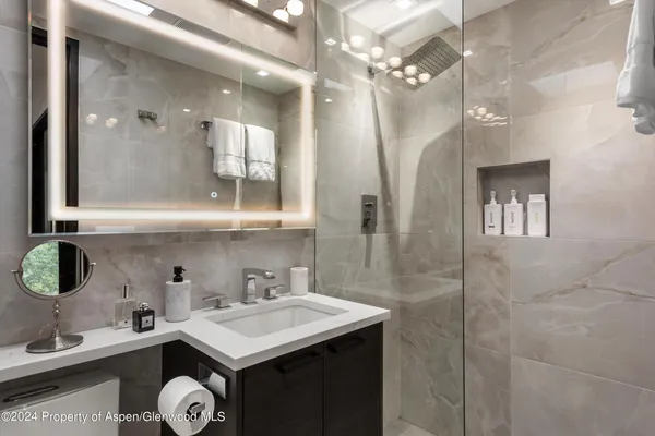 a bathroom with a sink a toilet and shower