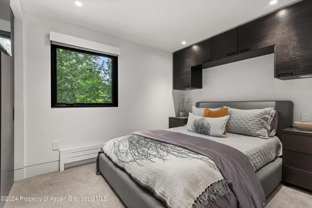 a bedroom with a large bed and a flat tv screen on dresser