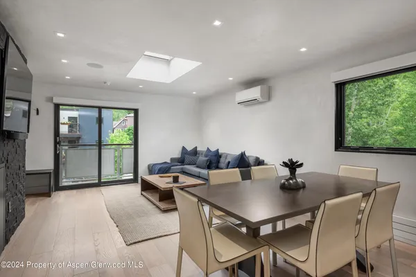 a view of a dining room with furniture wooden floor and a potted plant