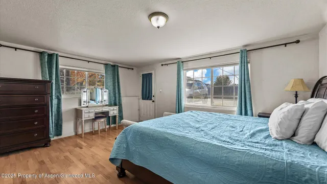 a bedroom with a bed and wooden floor