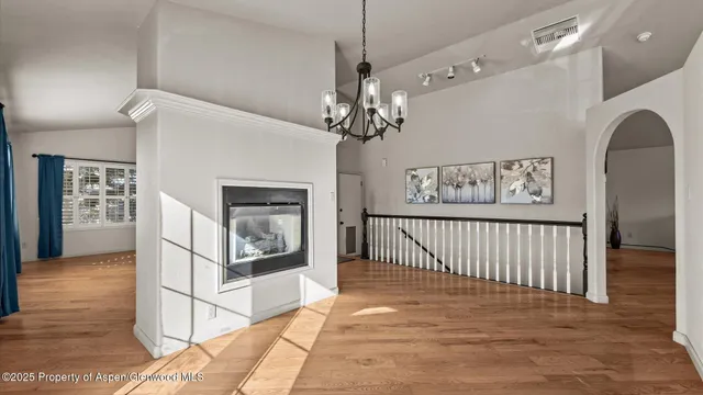 a view of a livingroom with wooden floor and a ceiling fan