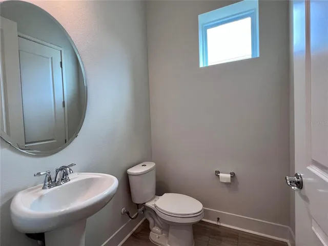 a bathroom with a granite countertop sink toilet a mirror and shower