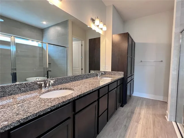 a bathroom with a tub a mirror and a shower